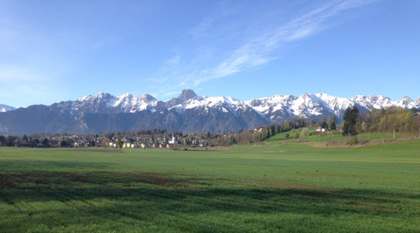 View of the village Uetendorf and the mountain Stockhorn from the surrounding farm fields.
